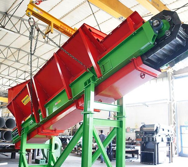 Trasportatore Apron Conveyor di Ghirarduzzi a colori rosso e verde, utilizzato in fonderia e riciclaggio