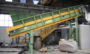 Ghirarduzzi's inclined yellow and green Apron Conveyor for efficient transportation