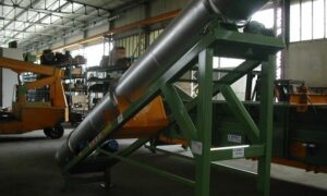 Ghirarduzzi rotary tube conveyor installed in an industrial plant, used for transporting challenging materials like powders, abrasive substances, and hot materials. The conveyor allows efficient inclined transport while minimizing dust emissions.