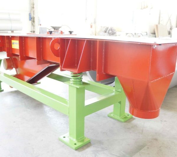 Vibrating channel by Ghirarduzzi Srl designed for precise material handling and dosing in industrial processes, featuring a durable red and green steel structure for efficient performance.